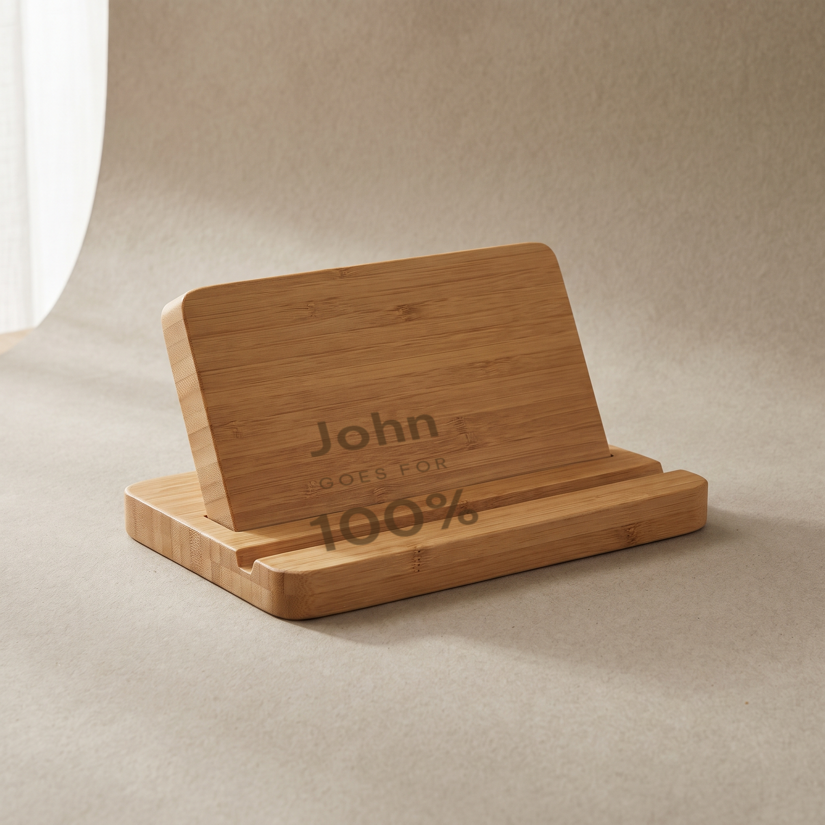 Bamboo phone holder engraved John GOES FOR 100%